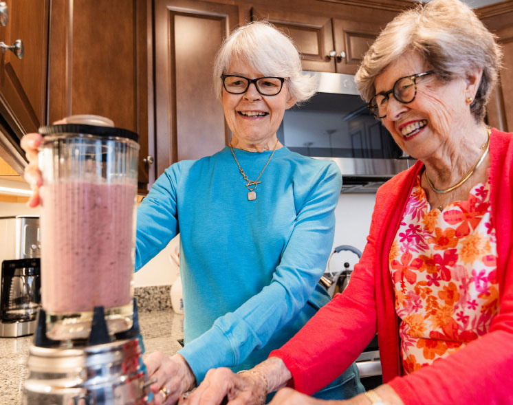 2 woman blending smoothies