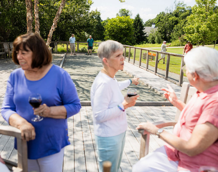 women drinking wine outside at game