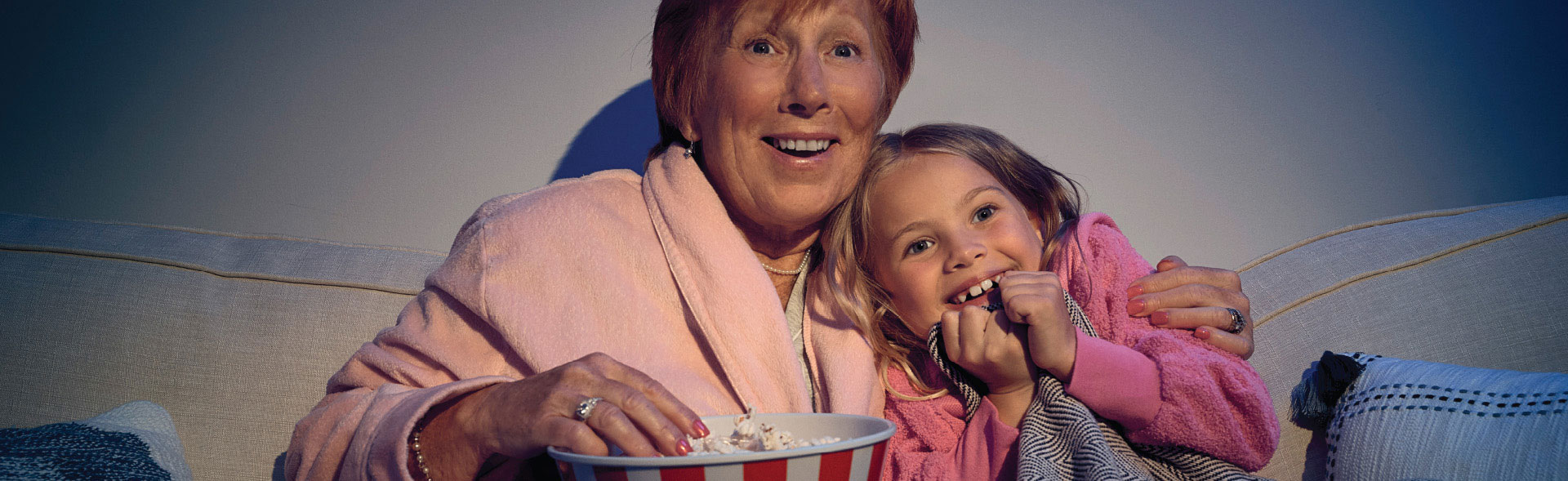 Woman with grandaughter eating popcorn